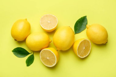 Taze olgun limonlar ve sarı arka planda yapraklar.