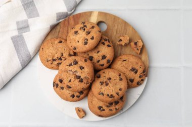 Çikolata parçacıklı kurabiyeler ışık masasının üstünde.