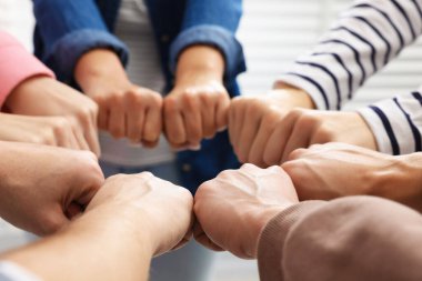 Kapalı mekanda el ele tutuşan insanlar, yakın çekim. Takım oluşturma