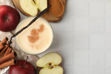 Lezzetli protein karışımı cam, elma, tarçın ve vanilya kabukları beyaz fayanslı masa, düz yatak. Metin için boşluk