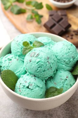 Gri masadaki kasede naneli çikolata parçacıklı dondurma, yakın plan.