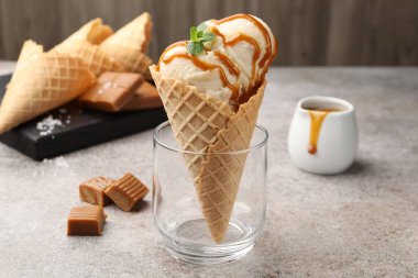 Tuzlu karamel soslu lezzetli dondurma ve gri masada naneli waffle. Yakın plan.