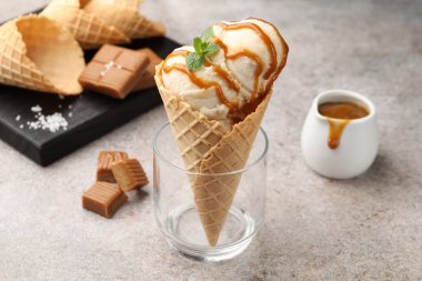 Tuzlu karamel soslu lezzetli dondurma ve gri masada naneli waffle. Yakın plan.