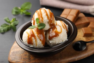 Karamel soslu lezzetli dondurma ve siyah masada nane şekeri.