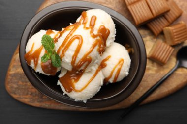 Karamel soslu lezzetli dondurma ve siyah masada nane şekeri.