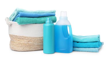 Çamaşır sepeti, havlular ve beyaza izole edilmiş deterjan şişeleri.