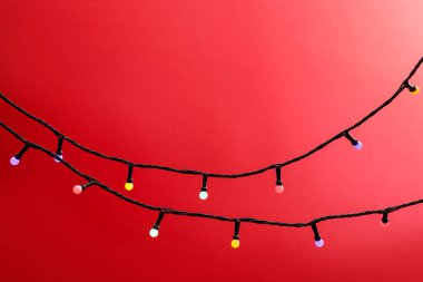 Kırmızı arka planda parlak Noel ışıkları, yakın plan. Metin için boşluk