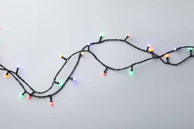 Gri arka planda parlak Noel ışıkları, üst manzara