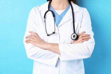 Açık mavi arka planda steteskoplu doktor, yakın plan.