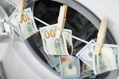 Çamaşır makinesinin yanındaki çamaşır ipinde asılı banknotlar.