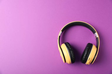 Mor arka planda şık kulaklıklar, üst manzara. Metin için boşluk