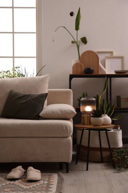 Kanepesi, lambası ve çiçekleri olan şık bir oturma odası. İç tasarım