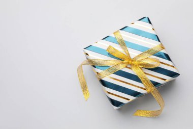 Işıklı arka planda güzel paketlenmiş bir hediye, üst manzara. Metin için boşluk