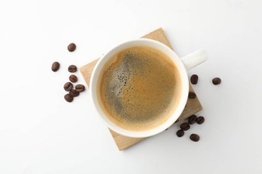 Beyaz arka planda bir fincan aromatik kahve ve kızarmış fasulye.