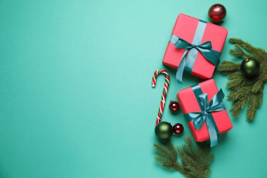 Paketlenmiş Noel hediyeleri ve yeşil arka planda dekorasyon, düz yatış. Metin için boşluk