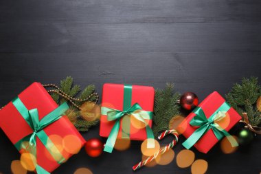 Noel hediyeleri ve siyah ahşap masa üzerindeki şenlikli dekor, düz yatış. Metin için boşluk