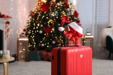 Bavul hediye ve bulanık ışıklara karşı evde Noel Baba şapkası. Noel tatili