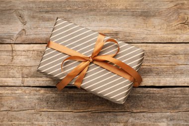 Tahta masada güzel paketlenmiş bir hediye, üst manzara.