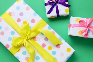 Yeşil arka planda güzel paketlenmiş hediyeler.