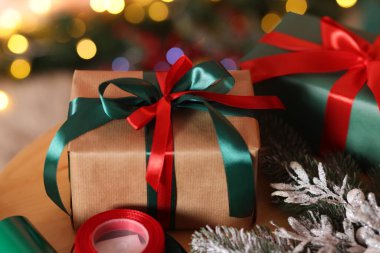 Güzel Noel hediyeleri ve ahşap masa üzerindeki şenlikli dekor, yakın plan. Bokeh etkisi