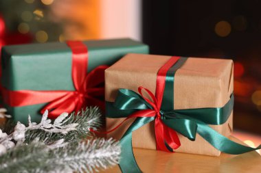 Güzel Noel hediyeleri ve ahşap masa üzerindeki şenlikli dekor, yakın plan. Bokeh etkisi