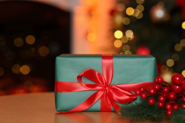 Güzel bir Noel hediyesi ve ahşap masa üzerinde şenlikli bir dekor, yakın plan. Bokeh etkisi
