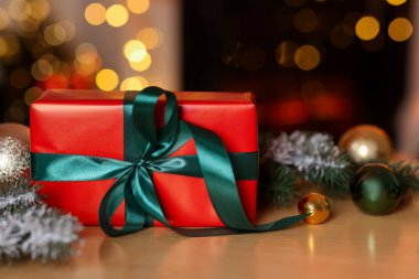 Güzel bir Noel hediyesi ve ahşap masa üzerinde şenlikli bir dekor, yakın plan. Bokeh etkisi