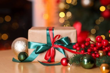 Güzel bir Noel hediyesi ve ahşap masa üzerinde şenlikli bir dekor, yakın plan. Bokeh etkisi