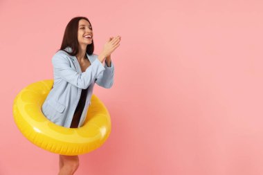 Pembe arka planda şişirilebilir yüzüğü olan iş kadını, mesaj için yer