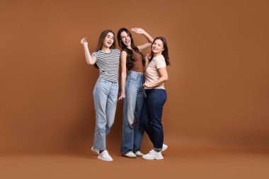 Kahverengi arka planda üç mutlu arkadaşın portresi