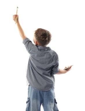 Fırça ve renk paleti olan çocuk beyaz arka plan, arka plan üzerine bir şey boyuyor