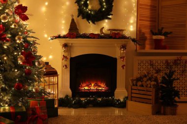 Güzel bir şömine, Noel ağacı ve karanlık odada şenlikli bir dekor. İç tasarım