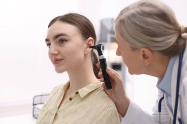 Duyma testi. Klinikte hastanın kulağını yıldız falıyla muayene eden doktor.