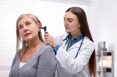 Duyma testi. Klinikte hastanın kulağını yıldız falıyla muayene eden doktor.