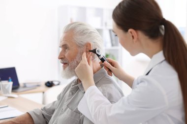 Duyma testi. Klinikte hastanın kulağını yıldız falıyla muayene eden doktor.