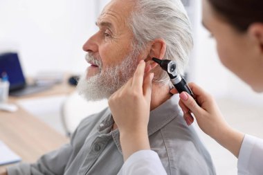 Duyma testi. Klinikte hastanın kulağını yıldız falıyla muayene eden doktor.