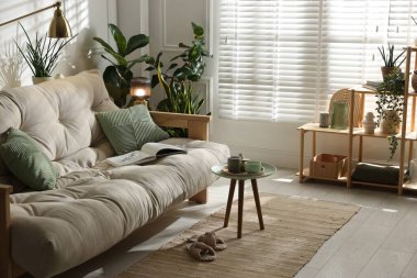 Kanepesi ve çiçekleri olan şık bir oturma odası. İç tasarım