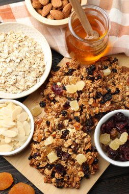 Kurumuş meyveli ve fındıklı lezzetli granola barları, siyah ahşap masa, düz uzanmış