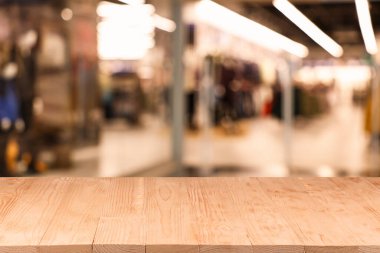 Boş ahşap masa, bulanık alışveriş merkezi manzarasına karşı. Tasarım için boşluk