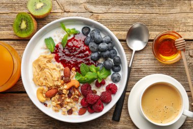 Sağlıklı kahvaltı. Fındıklı yulaf ezmesi, böğürtlen, yoğurt, kahve ve portakal suyu.