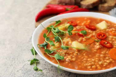 Gri masada servis edilen sebzeli lezzetli mercimek çorbası, yakın plan. Metin için boşluk