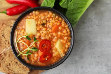 Gri masada servis edilen sebzeli mercimek çorbası. Metin için boşluk
