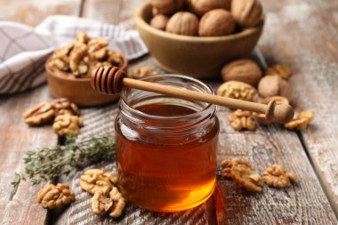 Kavanozda bal, ceviz, kekik ve ahşap masada kekik, yakın plan.