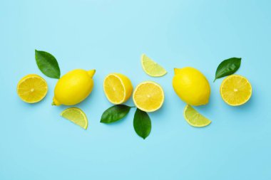 Taze olgun limonlar ve açık mavi arka planda yapraklar.