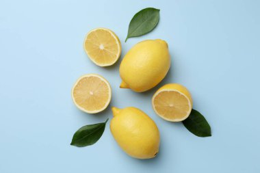 Taze olgun limonlar ve açık mavi arka planda yapraklar.