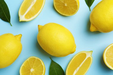 Taze olgun limonlar ve açık mavi arka planda yapraklar.