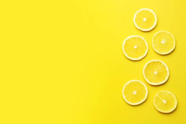 Sarı arka planda taze limon dilimleri, düz uzanmış. Metin için boşluk