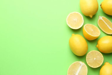 Açık yeşil zemin üzerinde taze olgun limonlar, düz uzanmış. Metin için boşluk