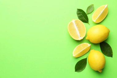 Taze, olgun limonlar ve açık yeşil arka planda yapraklar. Metin için boşluk