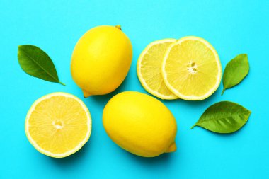 Taze olgun limonlar ve açık mavi arka planda yapraklar.